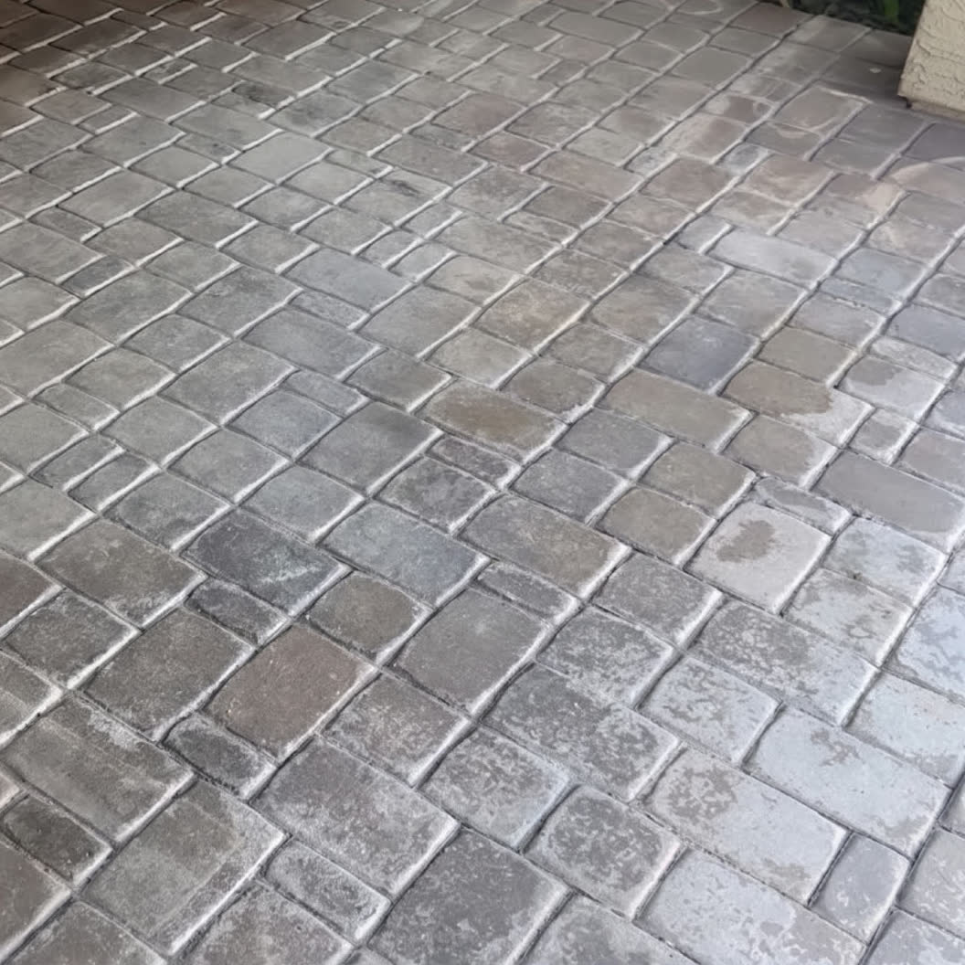 Cobblestone pavers before restoration — grey, chalky and washed out